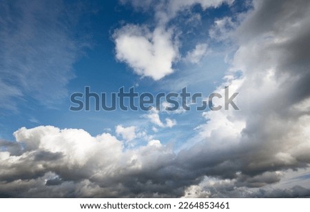 Epic cloudscape. White ornamental cumulus clouds before the rain. Fickle weather, sun rays. Clear blue sky. Natural pattern, texture, background, wallpaper, 3D, graphic resources, design, copy space