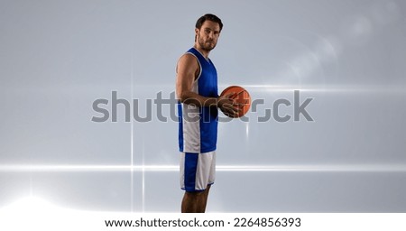 Composition of male basketball player holding basketball with copy space. sport and competition concept digitally generated image.