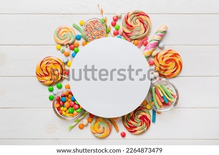 Flat lay holiday composition. Paper blank, lollipop, birthday decorations on Colored background. Top view, copy space for text.