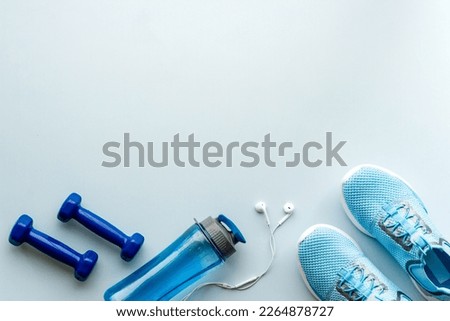 Athletics set with sneakers and dumbbells, top view. Royalty-Free Stock Photo #2264878727