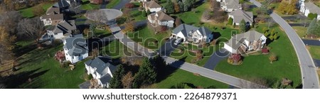 Panorama low density single family residential houses grassy yards landscaping in established development neighborhood in Rochester, Upstate New York. Aerial view two story home on large lot size Royalty-Free Stock Photo #2264879371