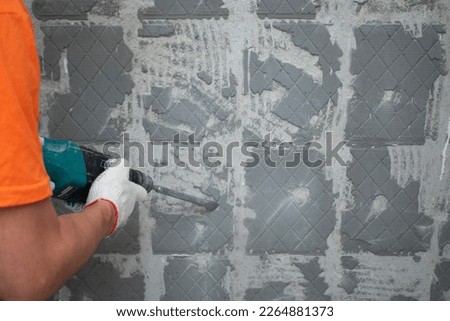 Dismantling work of tile adhesive with a jackhammer Royalty-Free Stock Photo #2264881373
