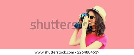 Summer portrait of happy smiling young woman photographer with film camera wearing straw hat on pink background, blank copy space for advertising text