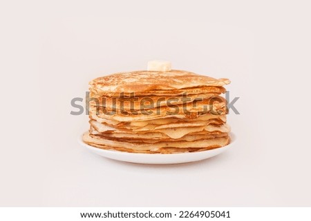 Staple of yeast fluffy pancakes with butter. Spring holiday Traditional Russian Shrovetide Maslenitsa week, pancake tuesday holiday. american crepes isolated on white gray background. side view Royalty-Free Stock Photo #2264905041