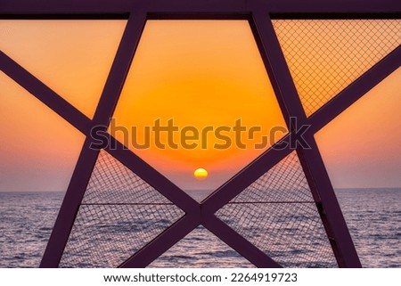 sunrise on the sea, looking through a pentagram sculpt