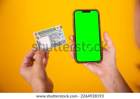 hand holding Brazilian car and vehicle driving license, CNH, smartphone with green screen