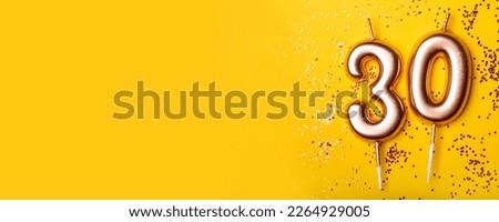 30 years celebration. Greeting banner. Gold candles in the form of number thirty on yellow background with confetti. Royalty-Free Stock Photo #2264929005