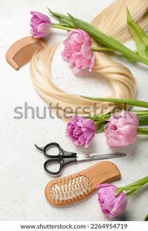 Hairdresser's tools with tulips on white background. Hello spring