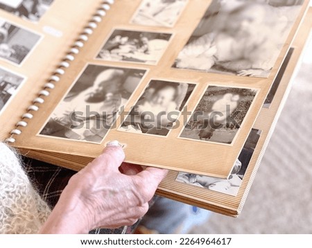 Elderly woman's hand looking at black and white photo album Royalty-Free Stock Photo #2264964617
