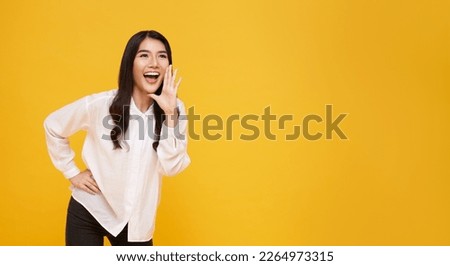 Asian woman with open mouths raising hands screaming announcement isolated on yellow copy space background. Royalty-Free Stock Photo #2264973315