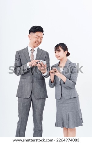Man and woman in suits with smartphones