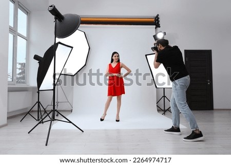 Beautiful young model posing for professional photographer in studio
