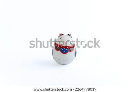 A Maneki-neko or also known as fortune cat in porcelain. Symbolizing luck and wealth, on a white isolated background.