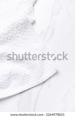 Fresh white towel lying on a white table. Vertical photography.