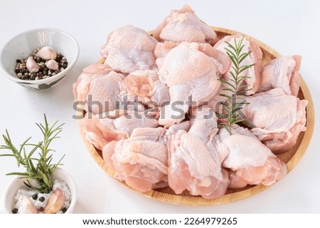 Fresh chicken fillet in wooden tray, salt, black pepper, white pepper and rosemary on white background. Royalty-Free Stock Photo #2264979265