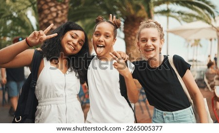 Three girls friends pre-teenage standing on the street smiling, hugging each other making faces for the camera. Three teenagers on the outdoors in urban cityscape background Royalty-Free Stock Photo #2265005377
