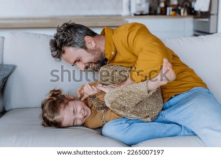 Father tickling his litttle daughter, having fun. Royalty-Free Stock Photo #2265007197
