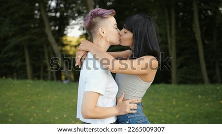 Lesbian LGBT female kissing outdoors in the park