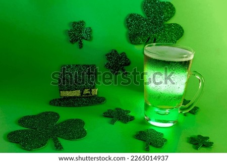 Beer mug with green light on green background with shamrock and hat, st patrick's day