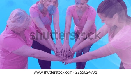 Composition of smiling female friends stacking hands on blue background. teamwork, motivation and success concept digitally generated image.