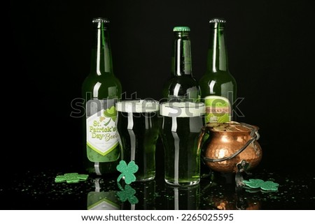 Glasses, bottles of beer and pot with golden coins on dark background. St. Patrick's Day celebration