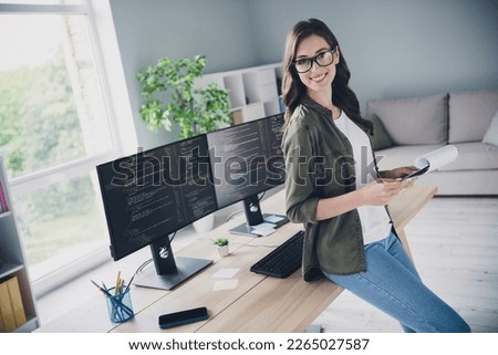 Photo of cheerful smart lady hardware expert pc operator hold document stand modern office center indoor room workstation