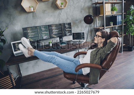 Photo of smiling dreamy lady programmer wear eyeglasses arms hands behind head having rest indoors workplace workstation
