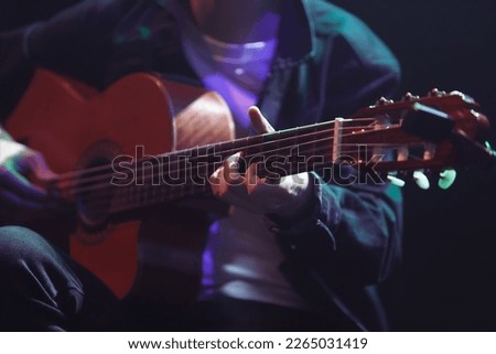 Guitarist playing solo part acoustic guitar on a rock concert  Royalty-Free Stock Photo #2265031419
