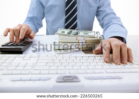 Businessman uses computing device, calculator / close-up photo of successful accountant working with computer keyboard in the office  Royalty-Free Stock Photo #226503265