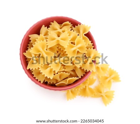 Bowl of raw farfalle pasta on white background