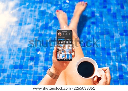 Woman viewing social media app on mobile phone by the pool