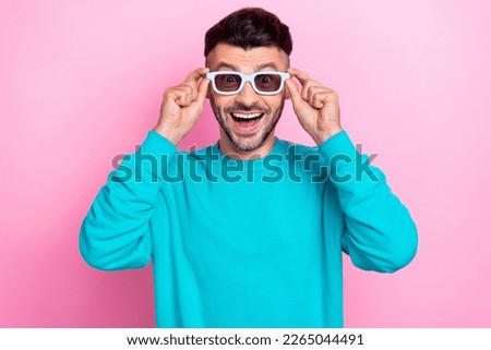 Photo of young excited positive funny guy trying his new 3d spectacles for watching virtual reality movies isolated on pastel pink color background
