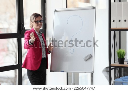 A happy woman speaker in an office with a marker near a white board, a close-up. Concept issue in the workplace