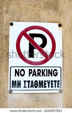 Close up of a no parking sign in both English and Greek languages                               