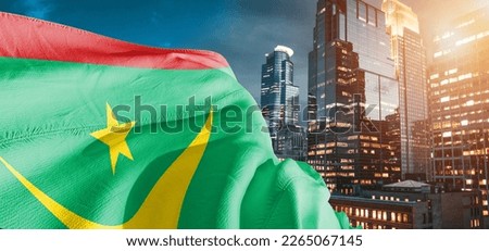 Mauritania national flag cloth fabric waving on beautiful buildings background.