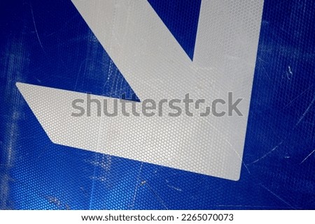 white arrow on a blue surface. Traffic sign background