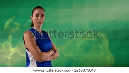 Composition of female basketball player standing with arms crossed, over smoke on green background. sport and competition concept digitally generated image.