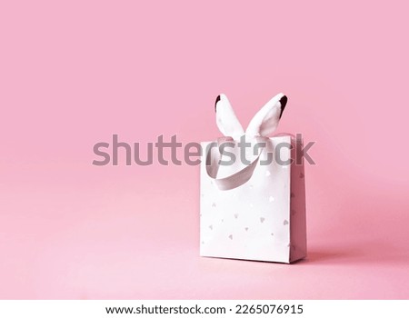 Easter bunny ears in a paper bag. Pink background. Space for text. Happy easter