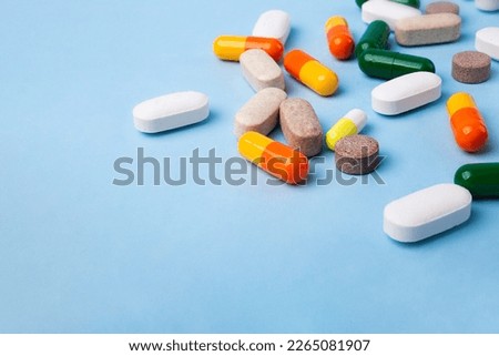 Top view of different pills on blue background,large banner with negative space.
