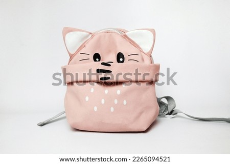a cute pink backpack with a kitty paw closes its mouth. bullying at school                              