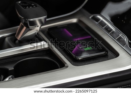 Wireless mobile charger in the modern car. Portable wireless car charger for smartphone. Royalty-Free Stock Photo #2265097125