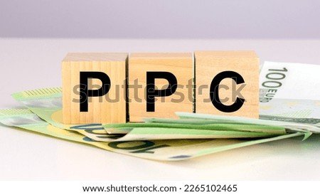 PPC - acronym Pay Per Click. text on wood cubes with euro bills