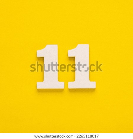 Number 11 - Two figures in white on a yellow background