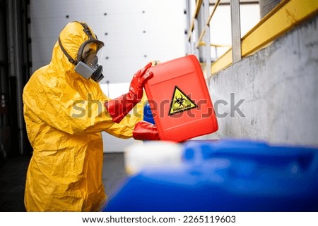 Working in chemicals industry. Professional worker in hazmat protection suit and gas mask working with dangerous and toxic materials. Royalty-Free Stock Photo #2265119603