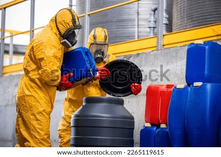 Chemical factory workers in protective equipment and gas masks mixing chemicals and acids. Royalty-Free Stock Photo #2265119615