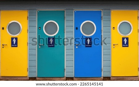 Unisex colourful  public toilet doors on the seafront at Weymouth in Dorset on the South Coast of England, UK