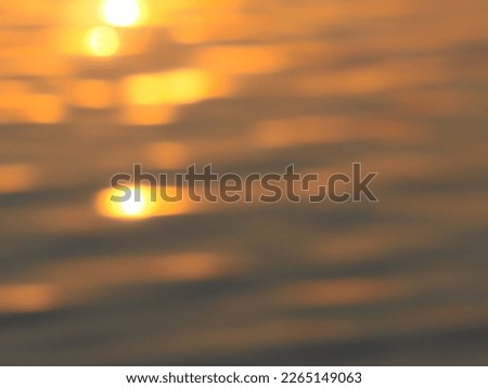 Golden blurred sunlight reflected on water surface at river for nature abstract background.