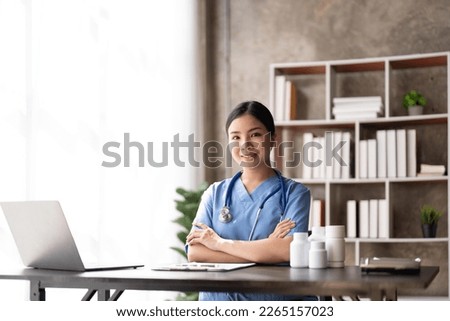 Young female doctor sitting and working in her clinic