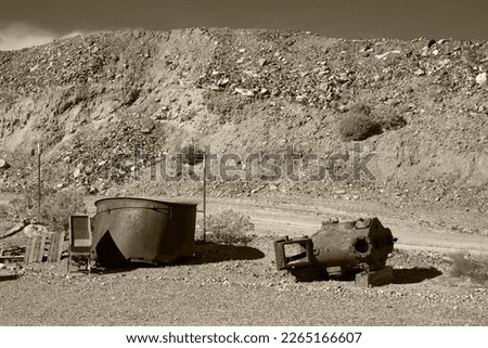 A sepia color picture of old rusty mining equipment and wastes