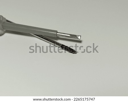 Blurry, defocus, and noisy image of two screwdrivers on white background
